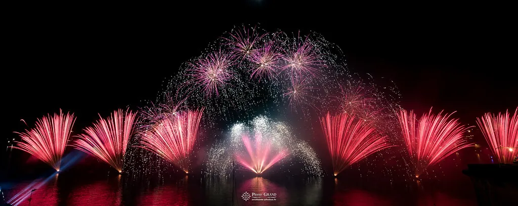 Éventails rouges sous une pluie d'étincelles roses, feu d'artifice du Grand Harbour, La Valette (Malte)
